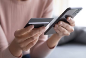 Credit Cards on UPI: FAQs - Women holding credit card and cellphone - IDFC FIRST Bank